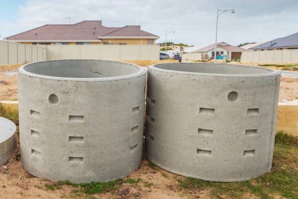 Two concrete soakwells with covers on the construction site before installation